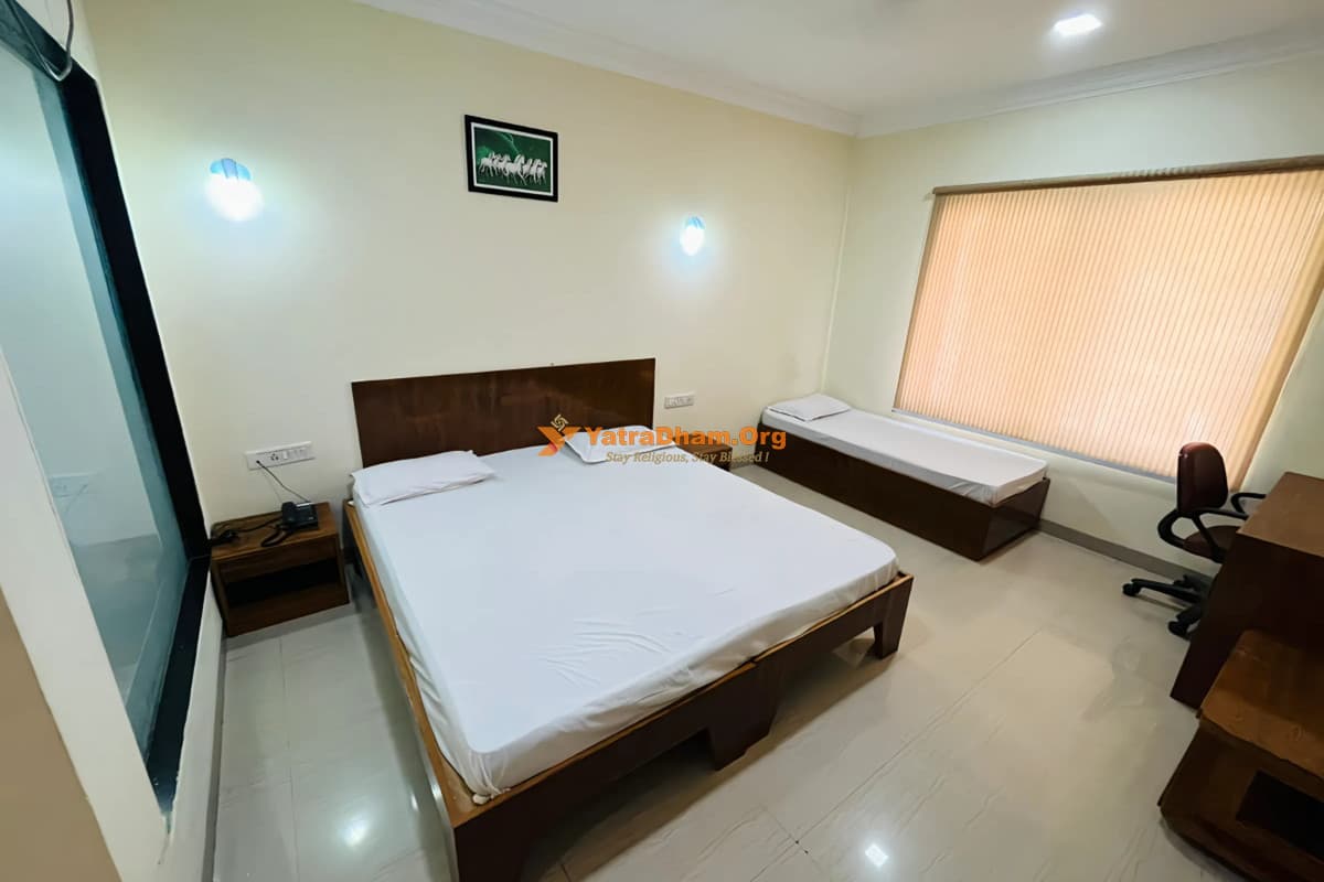 Three-Bed AC Room interior with double bed and single bed at Seth Murlidhar Mansinghka Yatri Niwas